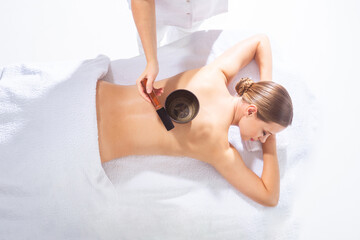 Young woman getting massaging treatment over white. Spa, healthcare and recreation concept.