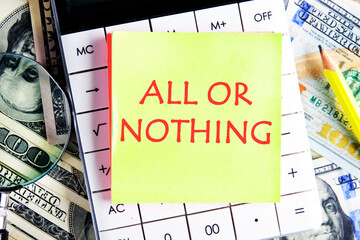 All or nothing, motivational phrase on the yellow sticker on the calculator on the background of dollars