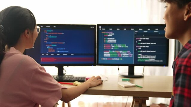 Slow motion back end software developer engineer for computer programming working together on debugging writing computing code, solving complex algorithms display on monitor in office. Burgeoning