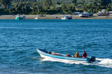 Un pescador y una compañera viajando a toda velocidad por el estero Huito, Calbuco Chile