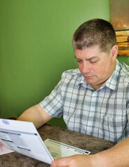 A Caucasian male reading voting ballot.