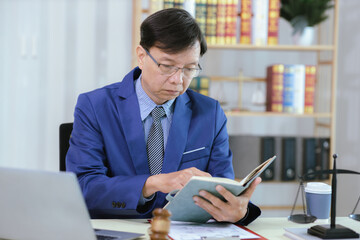 Lawyer sitting in his office On the table with a small hammer judge in court and the scales of...