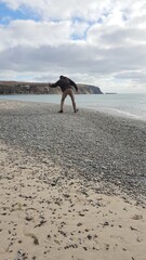 Man skimming rocks on the beach