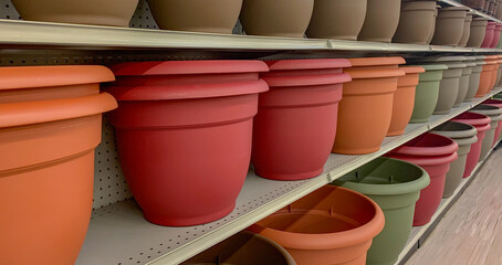 Resin/plastic pot planters on a display shelf at a gardening department.