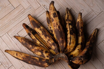 ripe bananas with black spots. served on wooden table. pisang matang.