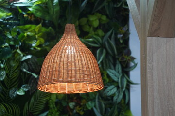 A braided lampshade with an electric light bulb.