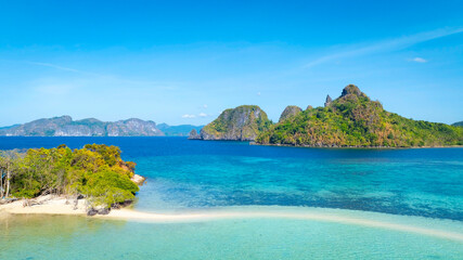 Fototapeta premium Aerail view of tropical exotic island sand bar separating sea in two with turquoise in El Nido, Palawan, Philippines.