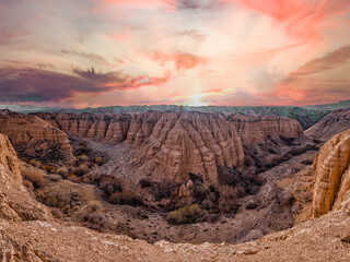 a clay canyon in the desert with an incredibly beautiful sky, carved with bizarre convolutions....