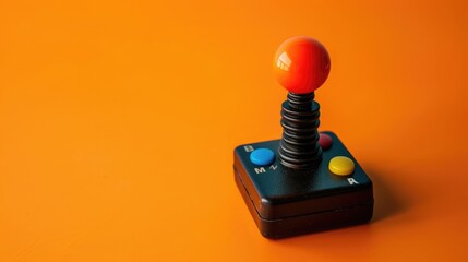 A retro arcade joystick placed on a bright orange background.