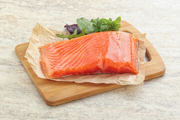 Raw salmon fillet over board