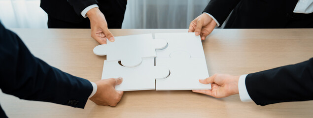 Panorama banner of business team assembling jigsaw puzzle over table symbolize business partnership...