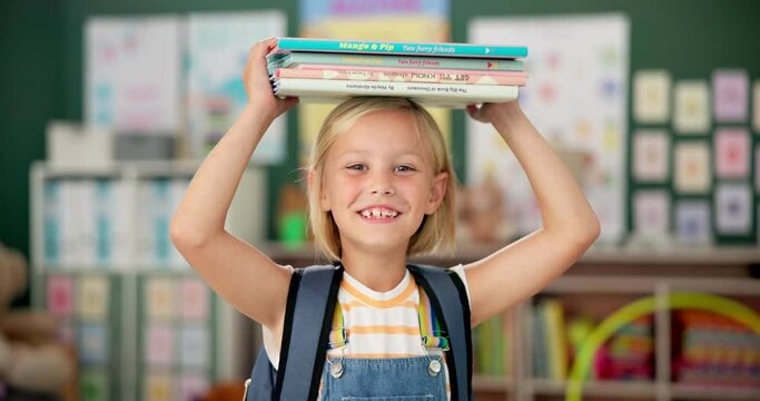 Happy, young girl and books on her head in kindergarten school for child development, growth and learning. Smile, female person or student with novel for story time with education, study and reading