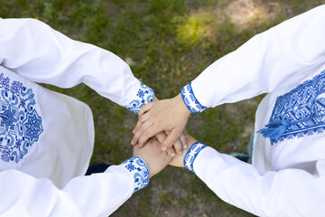 two children dressed in traditional embroidered Ukrainian clothes hold hands. concept of national...