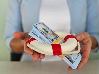 Person Holding Life Preserver With Money Inside