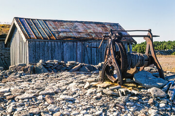 Old boat winch by a wooden shed on the coast