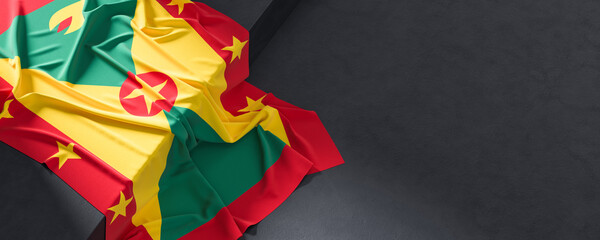 Flag of Grenada. Fabric textured Grenada flag isolated on dark background. 3D illustration