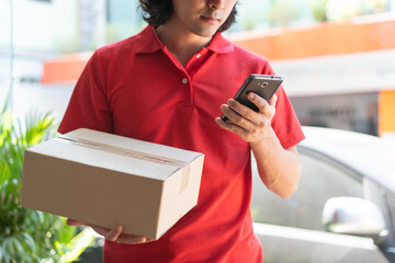 Delivery man looking customer address in mobile application. Selective focus on hand.