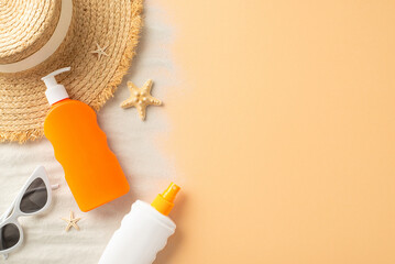 An overhead view of summer beach essentials including a straw hat, sunglasses, sunscreen bottles...