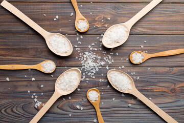 salt on many wooden spoon on wood background. Spoons with different salt