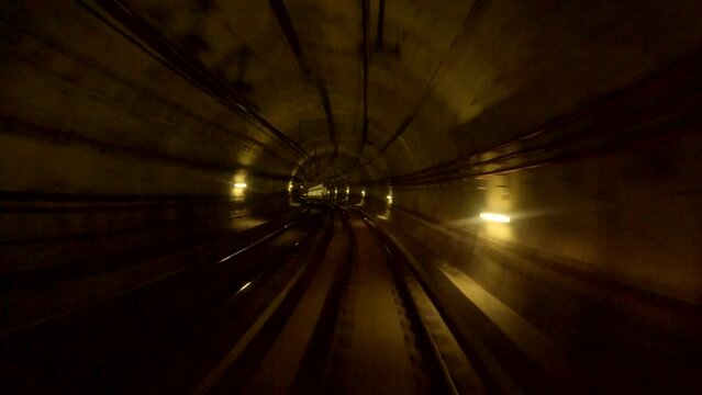 Time lapse, POV, train riding in the subway tunnel. Hyperlapse of automatic train moving to tunnel. A long-exposure shot of a subway tunnel, creating a motion blur effect with streaks of warm light
