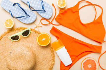 Swimming pool accessories concept. Top view of beach items on table, bright bikini, straw hat, and...