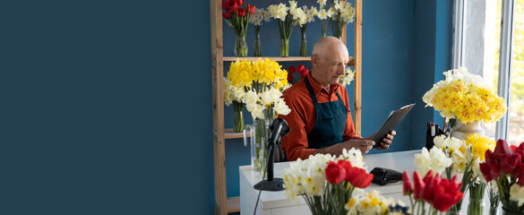 Elderly man florist studying papers