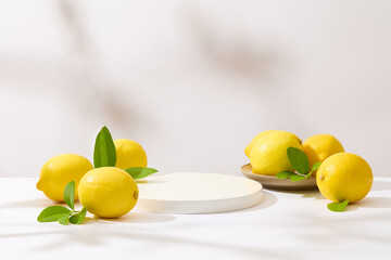 Plenty yellow lemons featured on table over white background with an empty podium in center for displaying beverage, culinary or skincare product, which made from lemon. Front view, blank space