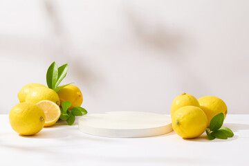 An blank pedestal placed in the center of photo, surrounded by some fresh lemons. Lemon juice has...