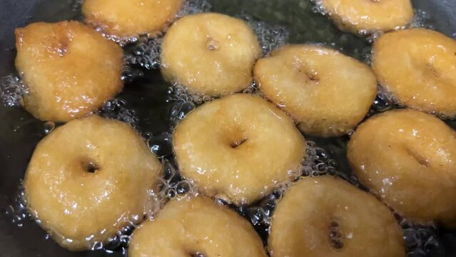 Medu Vada cooking and serving with coconut chutney.Top view of Indian veg breakfast food.Andhra breakfast cooking