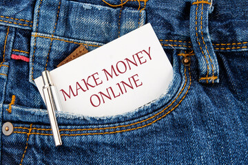 Business concept. MAKE MONEY ONLINE lettering written on a business card peeking out of a jeans...
