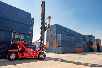 Forklift truck handling cargo shipping container box in logistic shipping yard with cargo container...