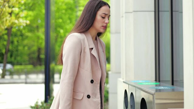 Pretty young woman standing outside holding cigarette between fingers and hesitating bringing it closer to lips. Confident caucasian female breaking cancer stick in half and throwing it away.