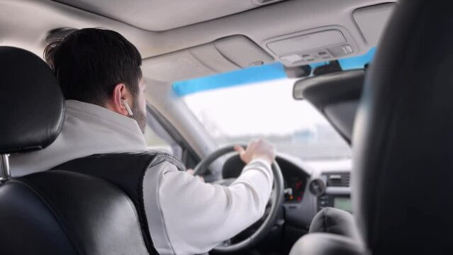man driving car on highway and listening to music with earpods