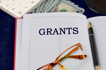 Business concept. Concept word grants in the businessman's notebook