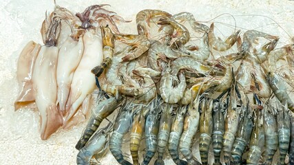 Freshly caught seafood, including squid and shrimp, displayed at a sea market, highlights the...