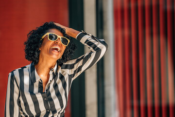 woman smiling happy on the street with sunglasses