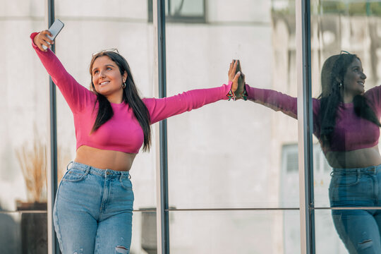 student with mobile phone on the street taking photo or recording