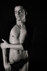 Naklejka premium A young attractive man with a beautiful body posing in the studio.
