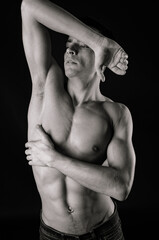 A young attractive man with a beautiful body posing in the studio.