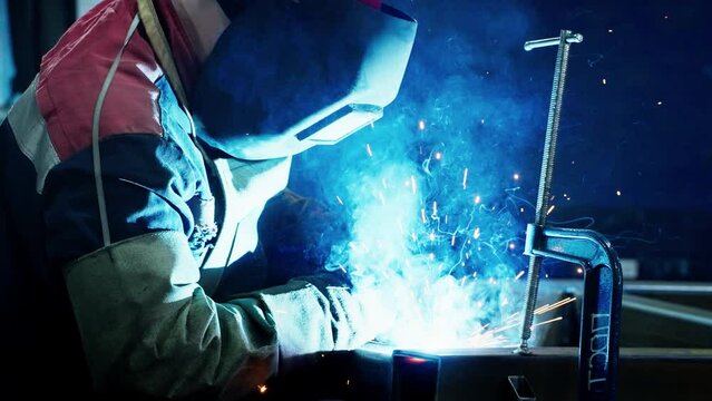 Professional Welder Working at factory facility. Factory workshop with a male technician welding in it