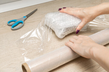 woman packing a parcel on the table.