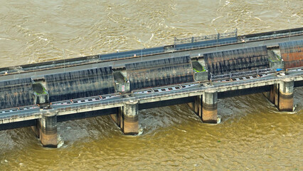 A resilient dam, adorned with lock gates, commands the river's rhythm, adapting to its ebbs and...
