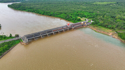 The colossal dam, stretching over the turbid river, boasts a sturdy railway bridge and fortified...