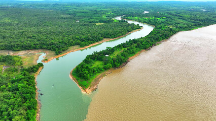 A natural spectacle unfolds as two rivers meet from a bird's eye view: one gleaming in rich orange...