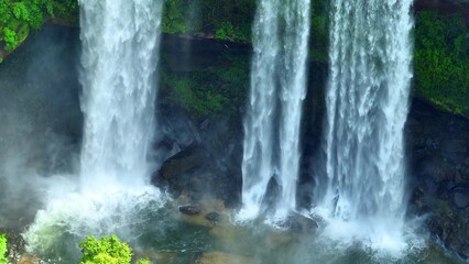 Immerse yourself in the sheer wonder of a magnificent waterfall, harmoniously embraced by the vivid...