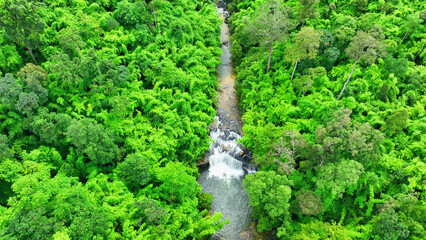 An awe-inspiring waterfall, harmonizing with the vibrant, emerald canopy of a tropical paradise. Pra on la or Waterfall, Phu Chong Na Yoi national park, Thailand. Bird's eye view.
