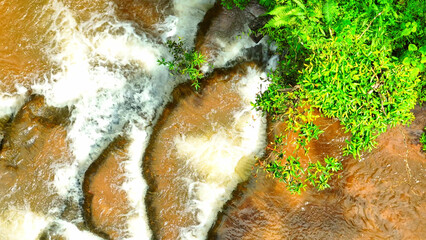 Deep in the jungle, our drone uncovered a mesmerizing waterfall, a hidden oasis, where the wild reigns, nature's raw power displayed in cascading layers. Exotic Rainforest. Thailand.
