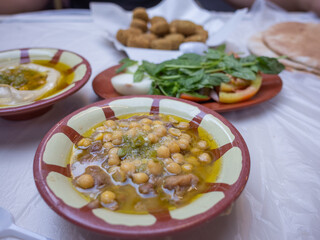 traditional arabic breakfast; hummus, falafel, foul, etc. on the table of the restaurant in capital amman