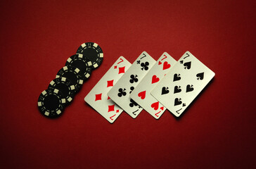Fototapeta na wymiar Four sevens in a poker game is a winning combination of four of a kind or quads on a red table in a club