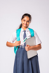 Indian asian beautiful little school girl posing with laptop against white background
